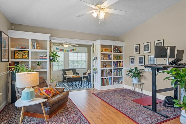 sitting room featuring ceiling fan, wood-type flooring, and a textured ceiling