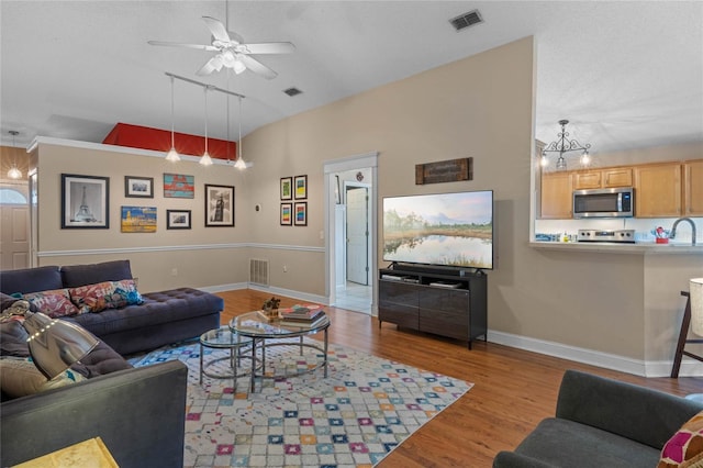 living room with lofted ceiling, sink, ceiling fan, and light hardwood / wood-style flooring