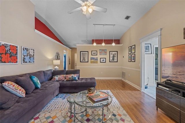 living room featuring vaulted ceiling, ceiling fan, light hardwood / wood-style floors, track lighting, and a textured ceiling