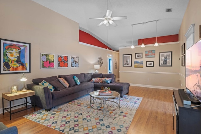 living room with ceiling fan, hardwood / wood-style floors, track lighting, a textured ceiling, and vaulted ceiling