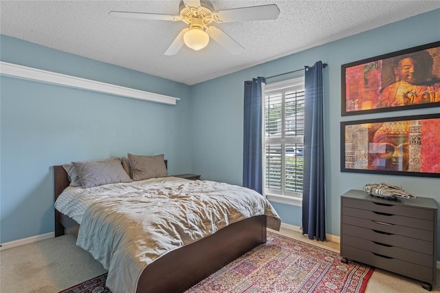 carpeted bedroom featuring a textured ceiling and ceiling fan