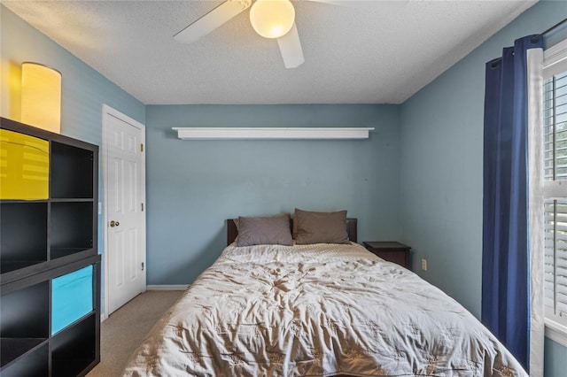 carpeted bedroom featuring a textured ceiling and ceiling fan