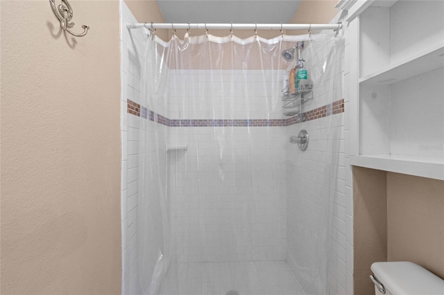 bathroom with a shower with curtain and toilet