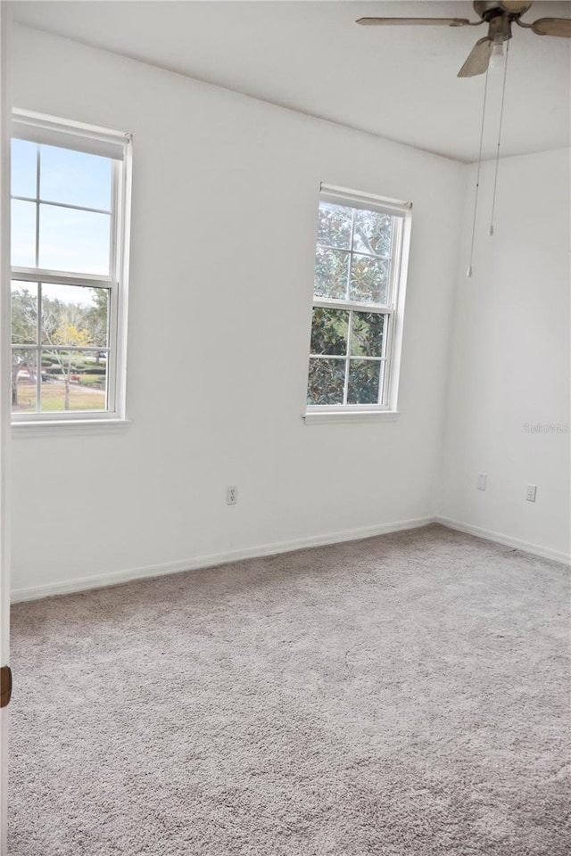 carpeted spare room featuring ceiling fan