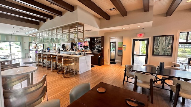 interior space with beam ceiling, a breakfast bar, and wooden ceiling