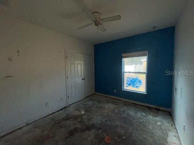 spare room with ceiling fan and concrete floors