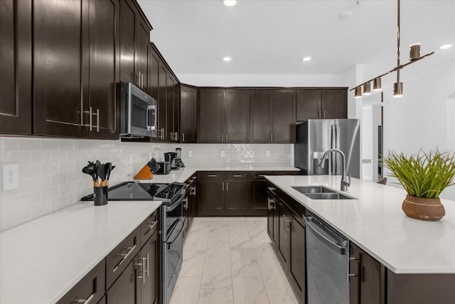 kitchen with tasteful backsplash, sink, hanging light fixtures, appliances with stainless steel finishes, and dark brown cabinets