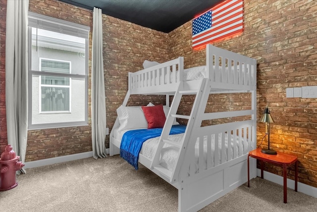 carpeted bedroom featuring brick wall