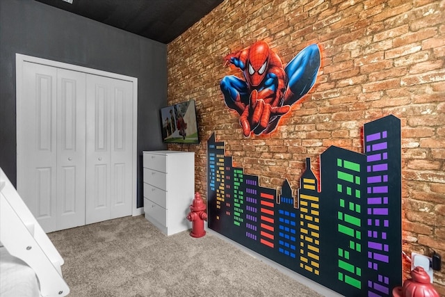 recreation room with brick wall and carpet flooring