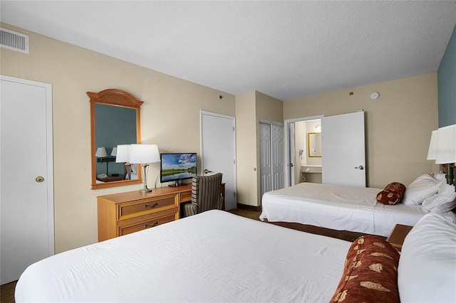 bedroom featuring connected bathroom and a textured ceiling