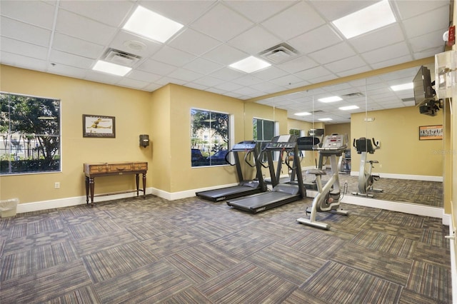 gym with dark colored carpet and a drop ceiling