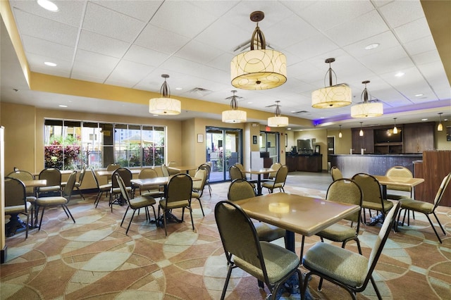 carpeted dining room with a raised ceiling