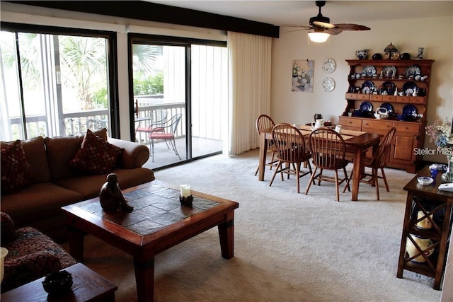 living room with ceiling fan, a wealth of natural light, and light carpet