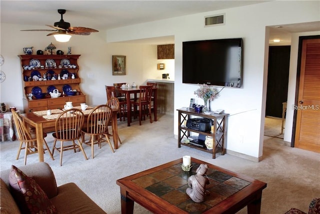 carpeted living room featuring ceiling fan