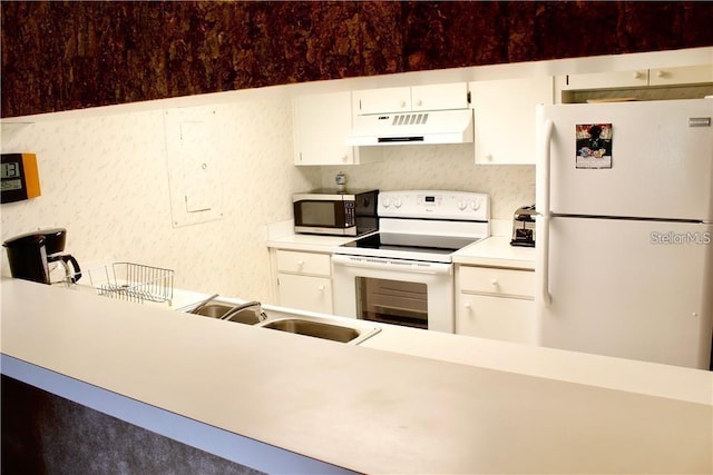 kitchen with sink, white appliances, and white cabinetry