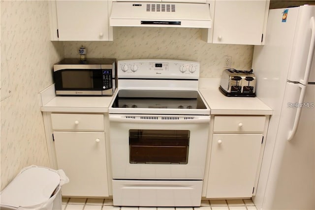 kitchen featuring range hood, light tile patterned floors, white cabinetry, and white appliances