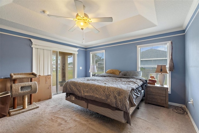 bedroom featuring light carpet, ceiling fan, a tray ceiling, access to exterior, and crown molding