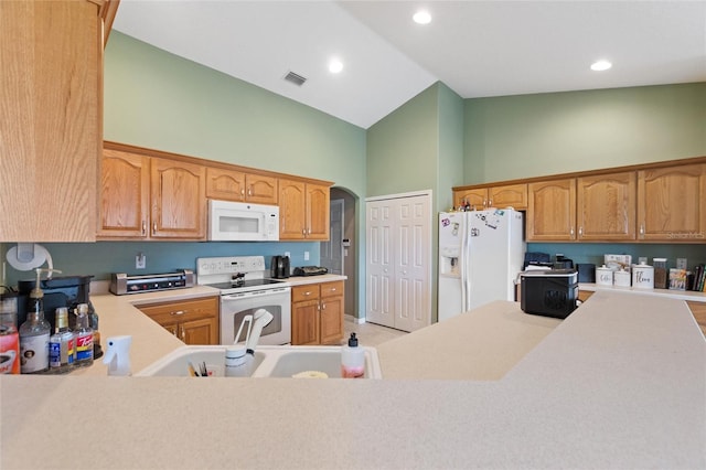 kitchen with high vaulted ceiling, kitchen peninsula, sink, and white appliances