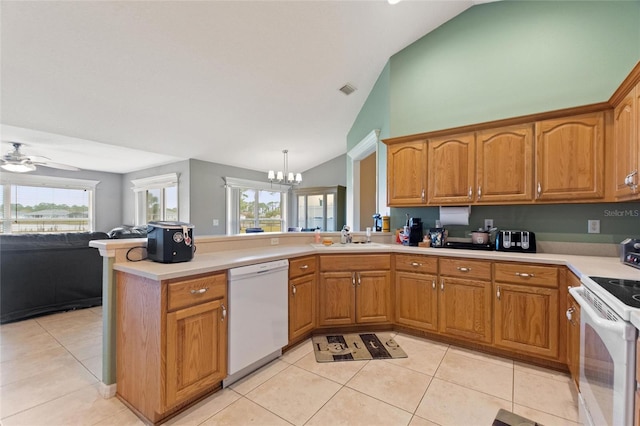 kitchen featuring pendant lighting, white appliances, sink, kitchen peninsula, and vaulted ceiling