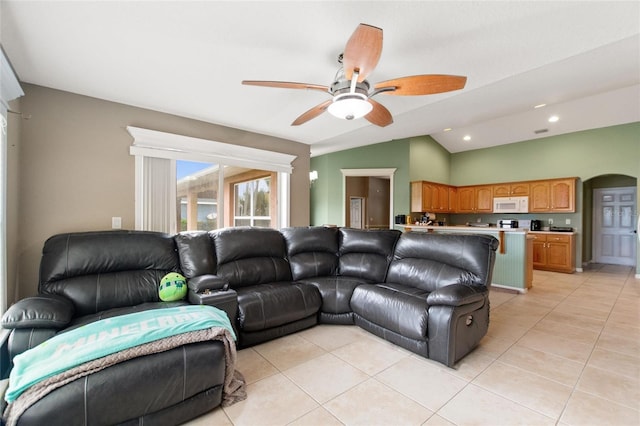 living room featuring ceiling fan, light tile patterned floors, and lofted ceiling