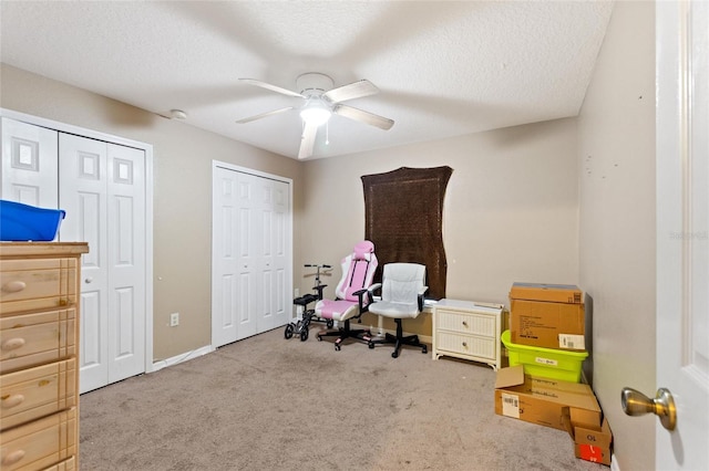 interior space with ceiling fan, light colored carpet, and a textured ceiling