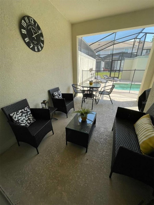 view of patio with an outdoor living space and glass enclosure