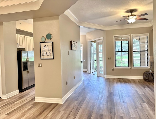 foyer entrance with a textured ceiling, ceiling fan, crown molding, and light hardwood / wood-style flooring