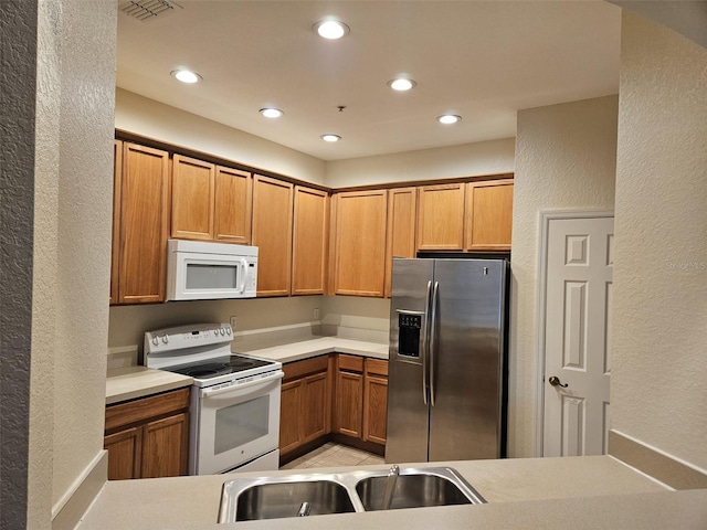 kitchen featuring light tile patterned floors, sink, and white appliances