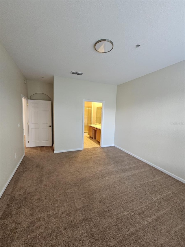 unfurnished room featuring a textured ceiling and light carpet