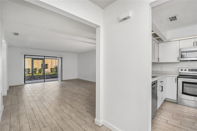 kitchen with white cabinets and appliances with stainless steel finishes