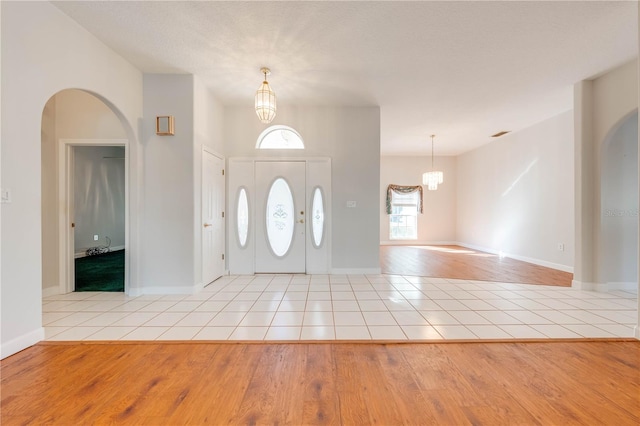 tiled foyer entrance with a chandelier