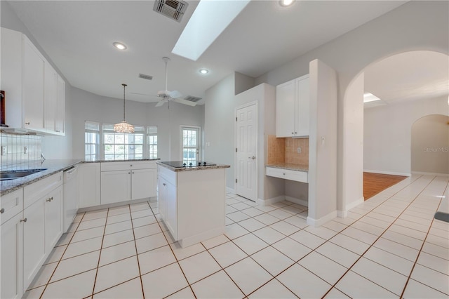 kitchen featuring ceiling fan, backsplash, light stone counters, and white cabinetry