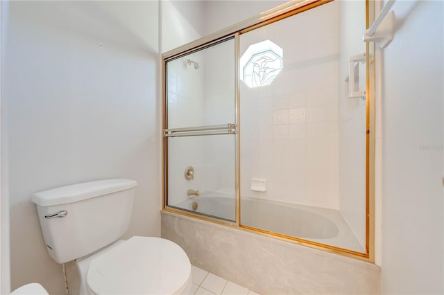 bathroom featuring toilet and shower / bath combination with glass door