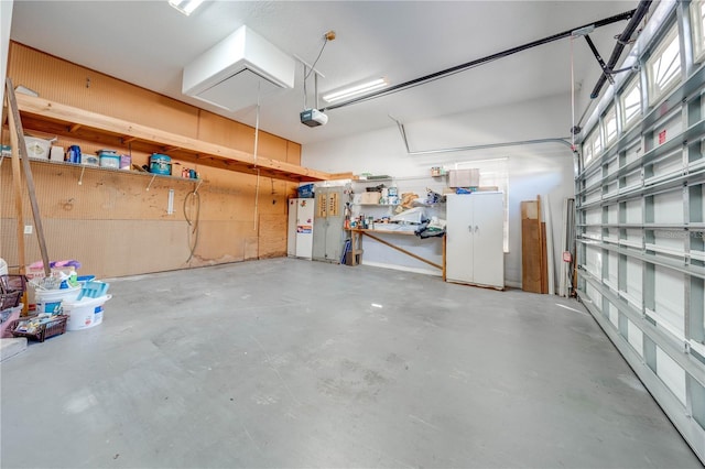 garage with a garage door opener and white refrigerator