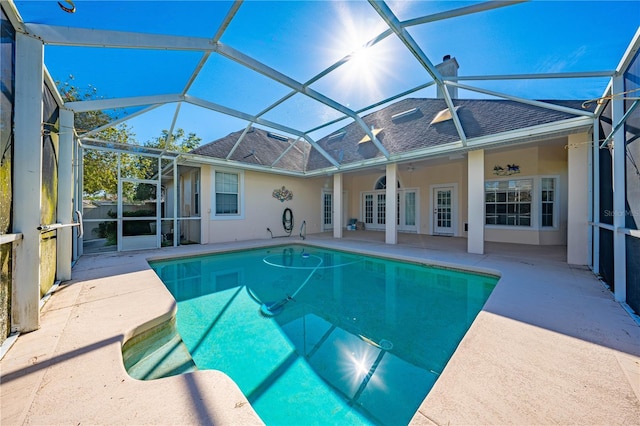 view of swimming pool with ceiling fan, french doors, a patio, and glass enclosure