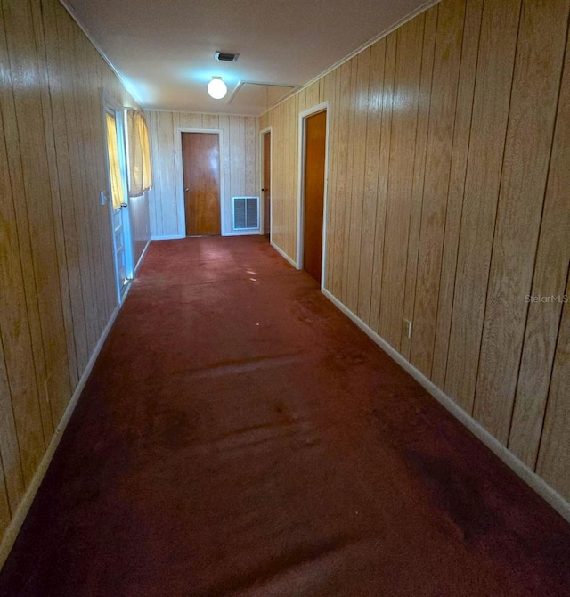 hallway with wood walls and carpet floors