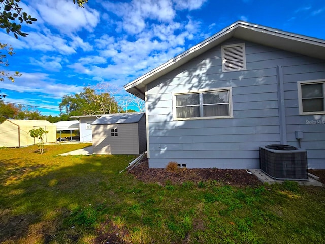 view of side of property with a lawn, a shed, and cooling unit