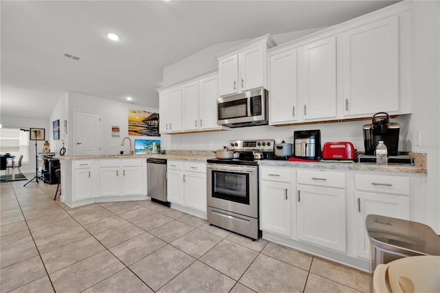 kitchen with light tile patterned floors, visible vents, appliances with stainless steel finishes, white cabinets, and a peninsula