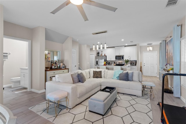 living room with ceiling fan and light wood-type flooring