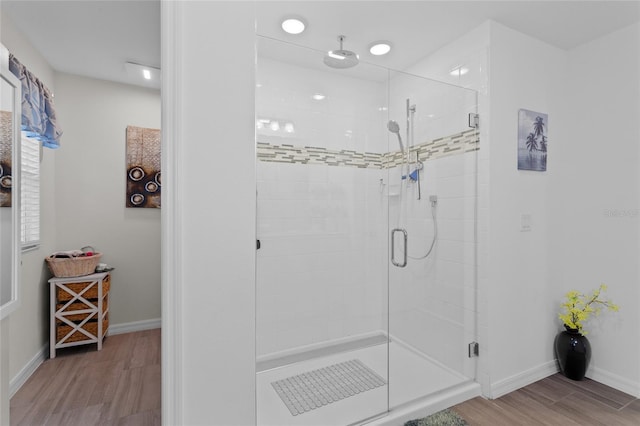 bathroom with an enclosed shower and hardwood / wood-style floors