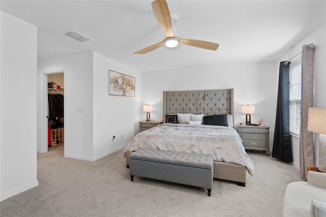 carpeted bedroom with a spacious closet and ceiling fan