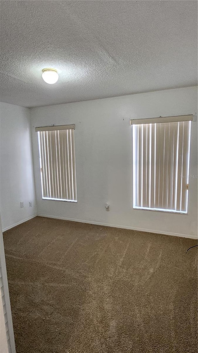 carpeted spare room with a textured ceiling