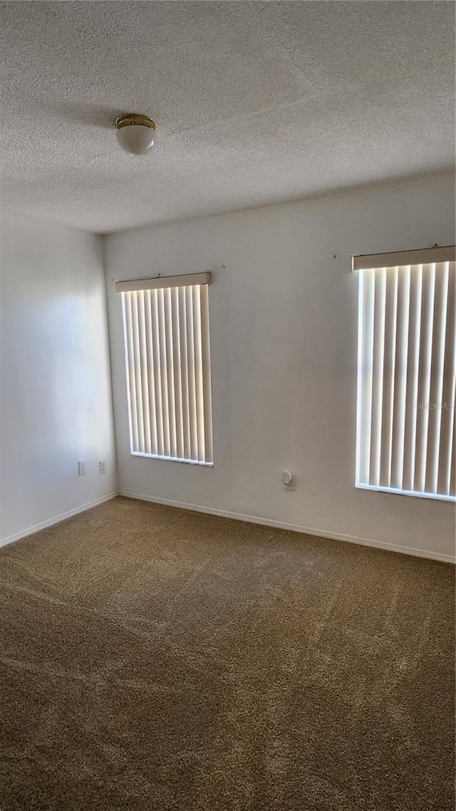 carpeted spare room featuring a textured ceiling