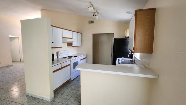 kitchen featuring lofted ceiling, sink, stainless steel refrigerator, white cabinetry, and electric range