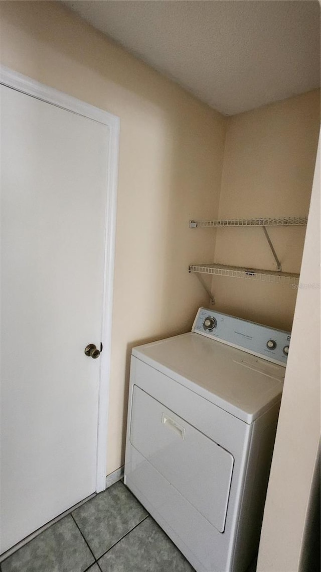 laundry area with light tile patterned flooring and washer / clothes dryer