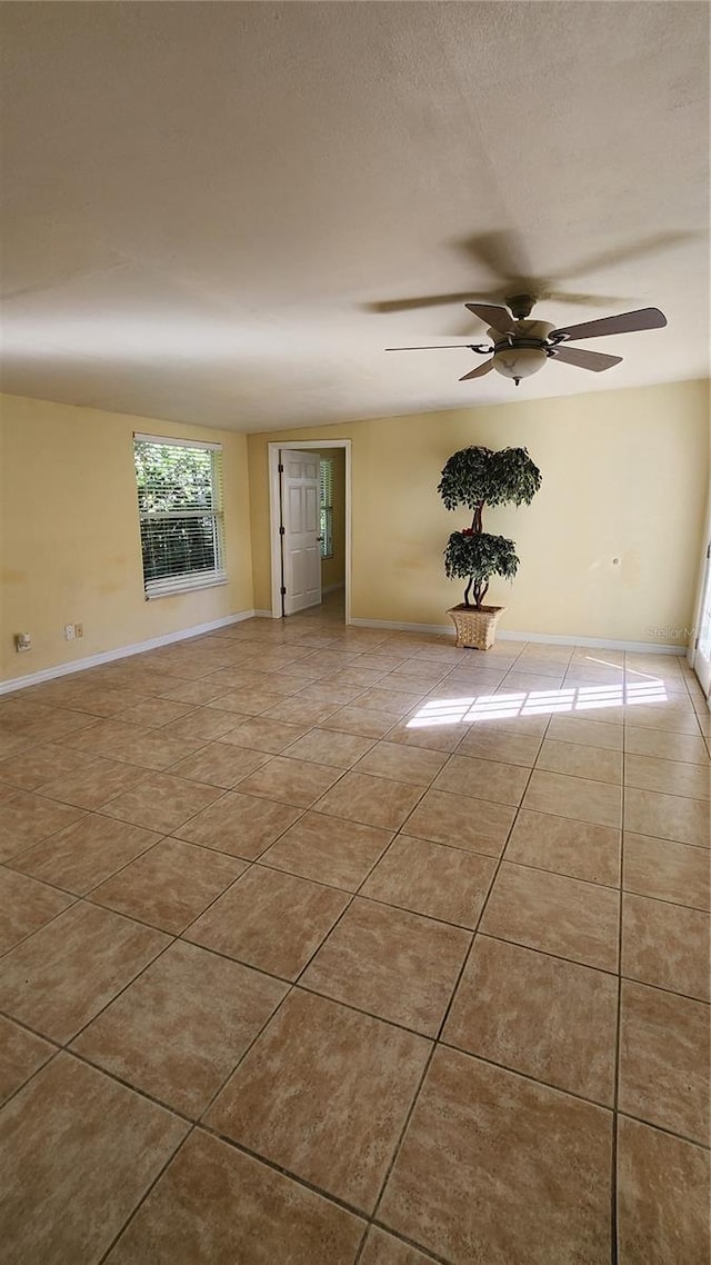 empty room featuring ceiling fan and light tile patterned floors