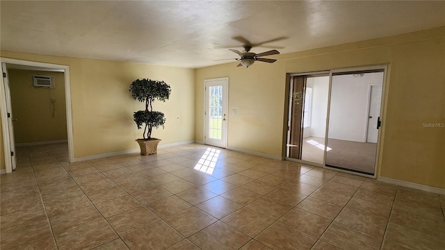 empty room with light tile patterned flooring, a wall mounted air conditioner, and ceiling fan