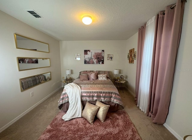 bedroom featuring light carpet and a textured ceiling