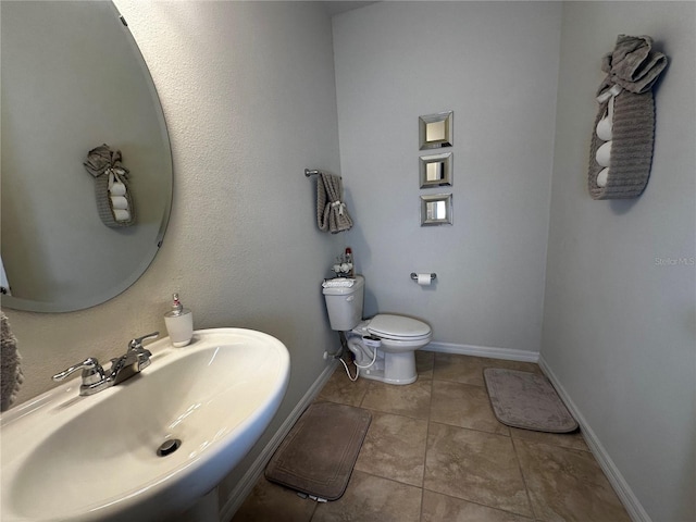 bathroom with tile patterned flooring, sink, and toilet