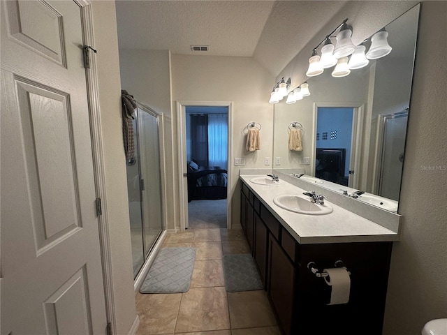 bathroom featuring tile patterned flooring, vanity, a shower with door, and a textured ceiling